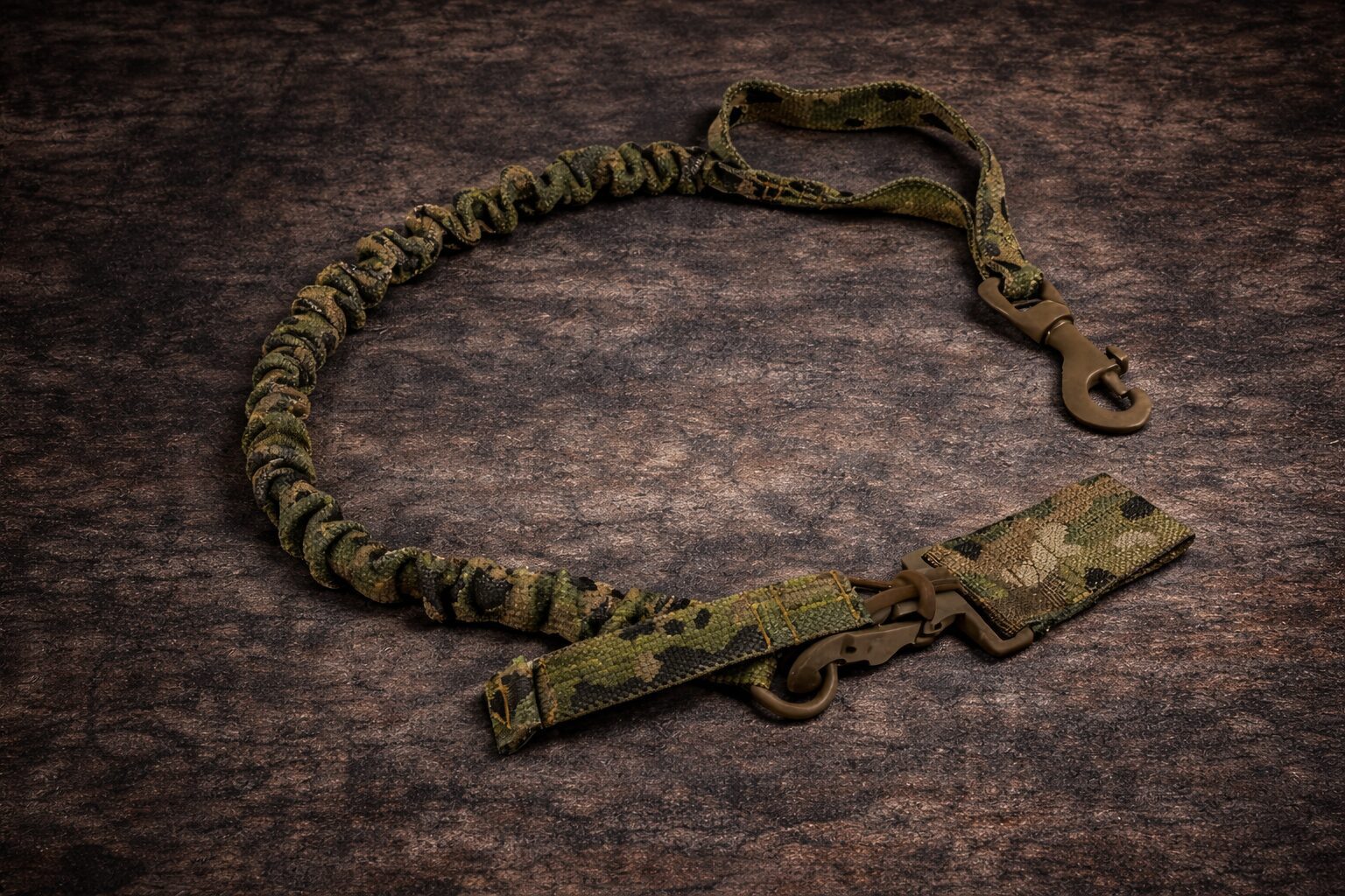 Tactical camouflage rifle sling on brown surface